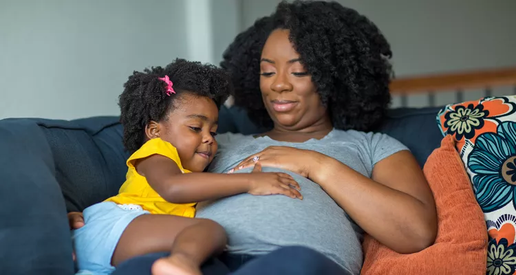 Pregnant woman holding a toddler