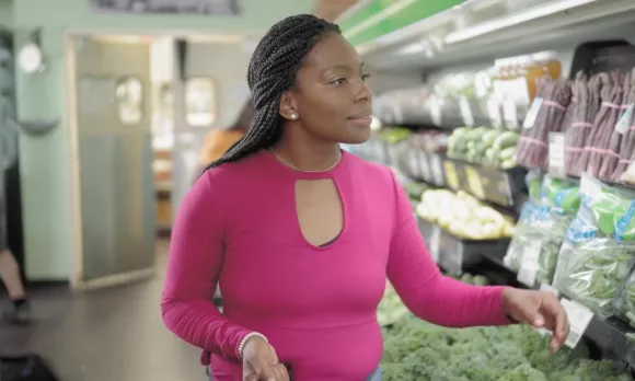 Woman in the produce aisle of a grocery shop. 